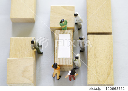 テーブルを囲んで話し合いをするミニチュアの人々 120668532