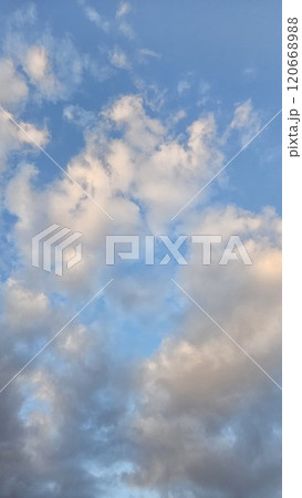 青空をバックにしたオレンジ色の雲 120668988