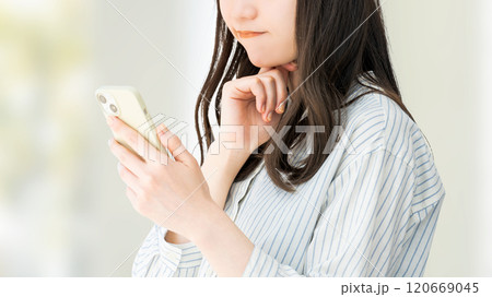 スマホを見て考える女性・ビジネスウーマン 120669045