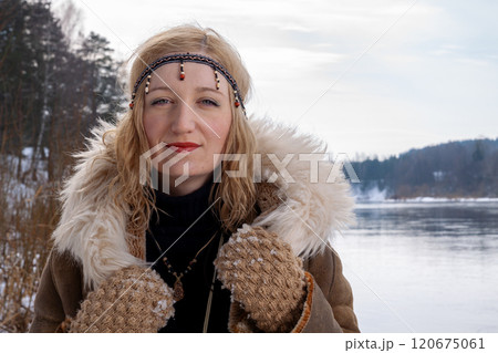A young woman with blonde hair dressed in a warm fur-lined leather coat A young woman with blonde hair dressed in a warm fur-lined leather coat 120675061