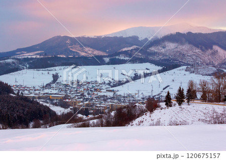 mountainous countryside landscape in winter. village in the valley. dramatic evening. snow covered hills. rural scenery 120675157
