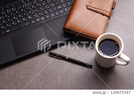 淹れたてのコーヒーを飲みながら、ノートパソコンとシステム手帳で、デスクワークをしているイメージ 淹れたてのコーヒーを飲みながら、ノートパソコンとシステム手帳で、デスクワークをしているイメージ 120675587
