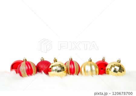 Red and gold Christmas balls ornaments placed on white fur on white background with copy space for text decoration 120678700