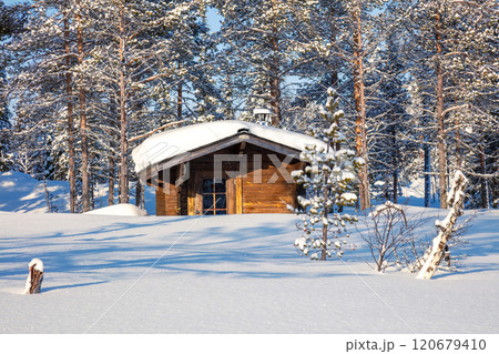 Small Log Hut in a Sunny Snowy Forest Small Log Hut in a Sunny Snowy Forest 120679410