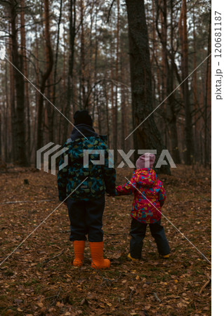 Two lost children in jackets and rubber boots hold on to mysterious autumn forests, in search of an exit. Bret and his sister were lost in the forest and wandered in circles in search of help. 120681187