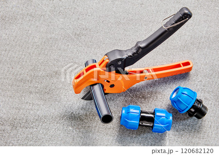 HDPE pipe cutter scissors is cutting water tube when installing household external pipeline for watering garden. HDPE pipe cutter scissors is cutting water tube when installing household external pipeline for watering garden. 120682120