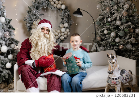 Santa claus giving christmas gift to a happy child 120682231