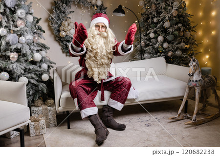 Santa claus sitting on white sofa changing poses 120682238