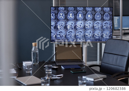 Background shot of X ray images of patients brain displayed on digital screen linked to laptop on conference table at radiologists office, copy space 120682386