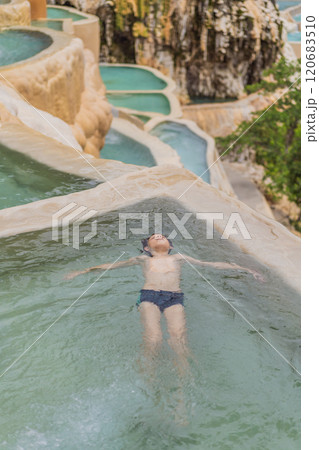 Teenage boy bathing in the hot springs of Grutas Tolantongo, Mexico. Family adventure, relaxation, and natural wellness concept 120683510