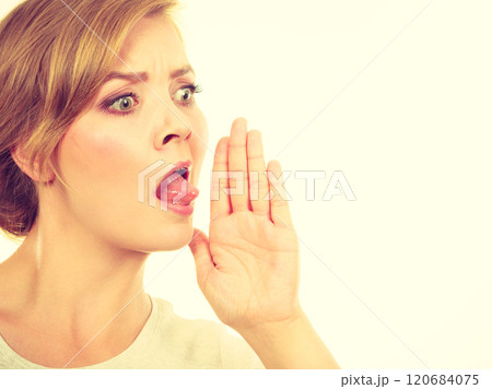 Woman whispering with hand close to mouth Woman whispering with hand close to mouth 120684075