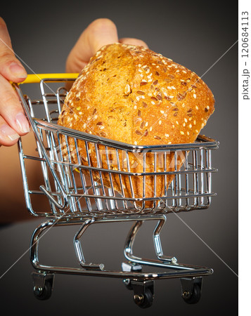 Woman hand holding shopping cart with bread Woman hand holding shopping cart with bread 120684113