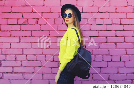 Fashion, stylish young woman in black hat, yellow sweater with backpack, girl posing on background 120684849