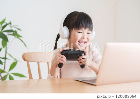 ノートパソコンでテレビゲームをする子供 ノートパソコンでテレビゲームをする子供 120685064
