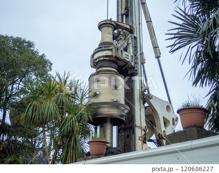 The work of the machine for drilling holes in the ground. Earth machine at work. Construction industry. The work of the machine for drilling holes in the ground. Earth machine at work. Construction industry. 120686227