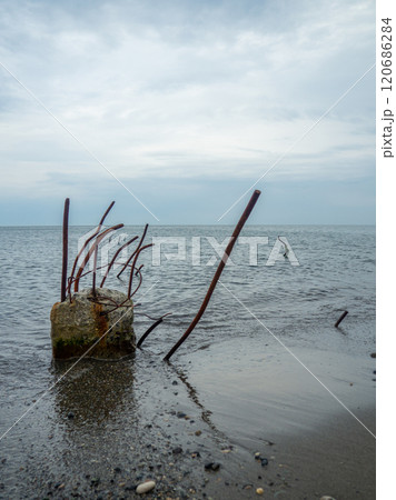 Reinforced concrete sticking out of the water. Remains of the structure. Abandoned. Armature at sea. A pile driven into the bottom of the sea. 120686284
