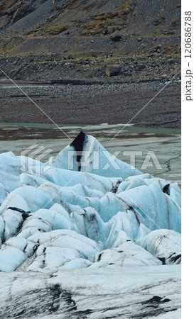 Diamond shaped Vatnajokull glacier forming ice caves in wintry iceland scenery near frozen glacier lagoon. Beautiful massive icebergs and ice chunks create icelandic landscape. 120686788