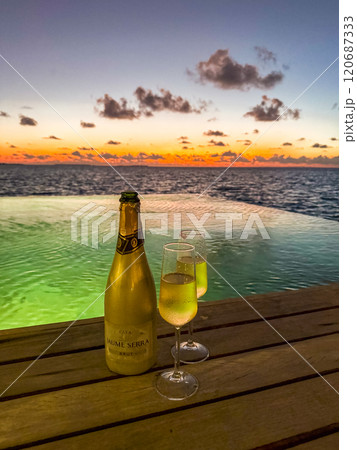 Sunset views from overwater pool villa in Maldives 120687333
