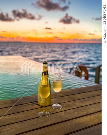 Sunset views from overwater pool villa in Maldives 120687343