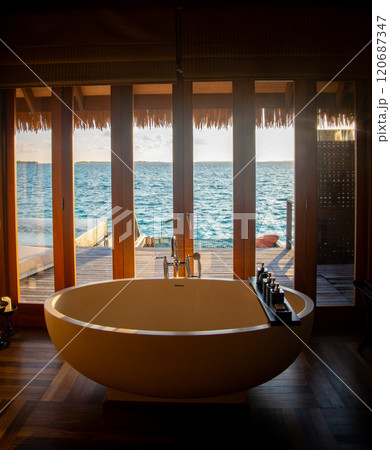 Sunset views from overwater pool villa in Maldives 120687347