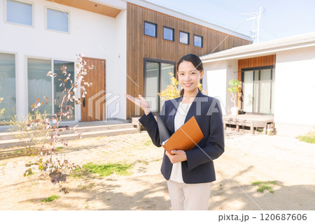 家の前に立つ不動産販売スタッフ 120687606