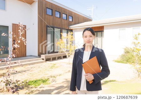 家の前に立つ不動産販売スタッフ 120687639