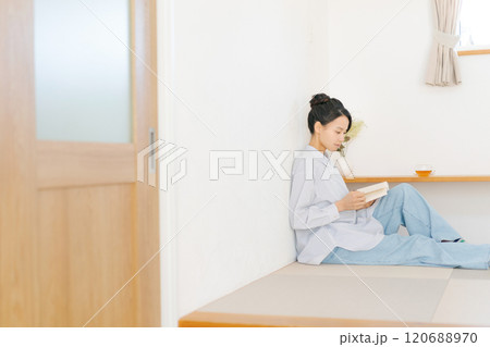 和室スペースに座って本を読む女性 120688970
