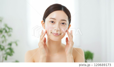 明るい室内で笑顔でスキンケアをする若い女性 明るい室内で笑顔でスキンケアをする若い女性 120689173