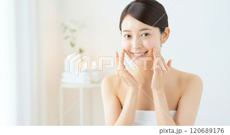 白基調の部屋で笑顔でスキンケアをする女性 白基調の部屋で笑顔でスキンケアをする女性 120689176