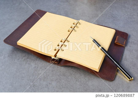 リング式のシステム手帳を開いてデスクワークをしているイメージ リング式のシステム手帳を開いてデスクワークをしているイメージ 120689887