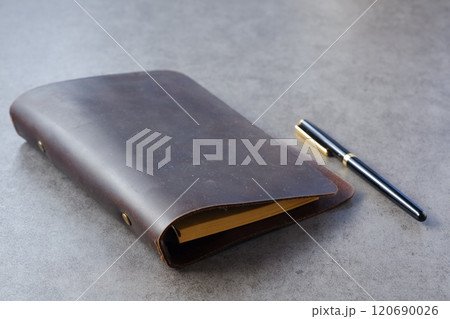 茶色の革のシステム手帳でデスクワークをしているイメージ 120690026