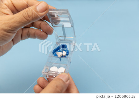 Senior man using pill splitter or pill cutter. Senior man using pill splitter or pill cutter. 120690518