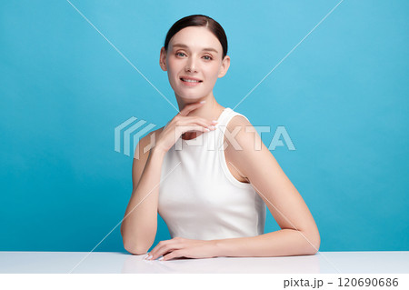 Beautiful young woman with clean fresh skin on blue background, Face care, Facial treatment, Cosmetology, beauty and spa, women portrait. Beautiful young woman with clean fresh skin on blue background, Face care, Facial treatment, Cosmetology, beauty and spa, women portrait. 120690686