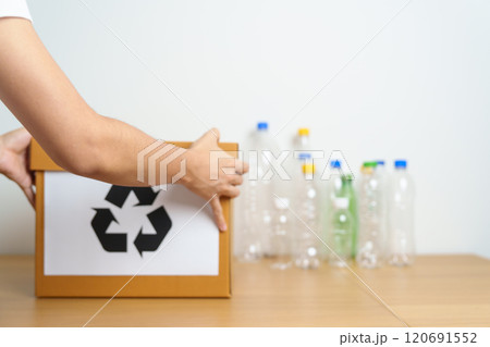 Volunteer keep plastic bottle into paper box at home or office. Hand Sorting Recycle garbage. Ecology, Environmental, pollution, Dispose recycling, waste management and trash Separation concept 120691552