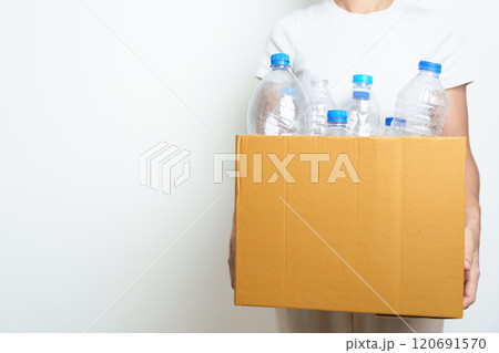 Volunteer keep plastic bottle into paper box at home or office. Hand Sorting Recycle garbage. Ecology, Environmental, pollution, Dispose recycling, waste management and trash Separation concept 120691570
