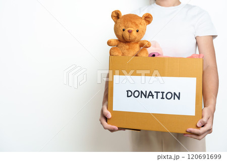 Kid Donation, Charity, Volunteer, Giving and Delivery Concept. Hand holding Bear doll and Clothes into Donation box at home for support and help poor, refugee and homeless people. Copy space for text Kid Donation, Charity, Volunteer, Giving and Delivery Concept. Hand holding Bear doll and Clothes into Donation box at home for support and help poor, refugee and homeless people. Copy space for text 120691699