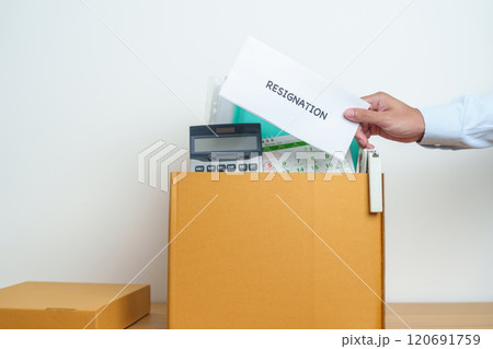 Resignation, Layoff, Unemployment, Dismiss, Job quit, Jobless and Farewell concept. Businessman holding letter of Resign contract with documents cardboard box at office 120691759