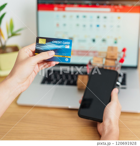 woman hand holding credit card and using laptop with mobile phone for online shopping while making order. Marketplace platform website, technology, ecommerce, shipping delivery and online payment 120691928