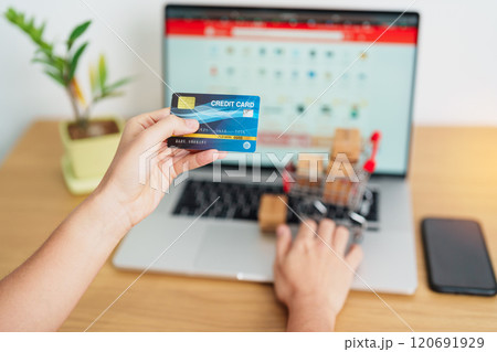 woman hand holding credit card and using laptop with mobile phone for online shopping while making order. Marketplace platform website, technology, ecommerce, shipping delivery and online payment woman hand holding credit card and using laptop with mobile phone for online shopping while making order. Marketplace platform website, technology, ecommerce, shipping delivery and online payment 120691929