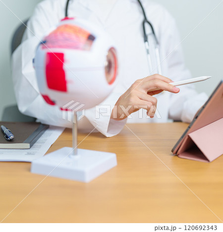 Doctor with human Eye anatomy model with magnifying glass. Eye disease, Refractive Errors, Age Related Macular Degeneration, Cataract, Diabetic Retinopathy, Glaucoma, Amblyopia, Strabismus and Health 120692343