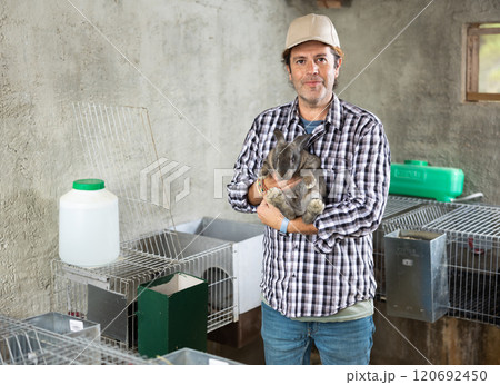 Male middle aged european worker holding rabbit 120692450