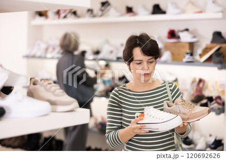 Woman takes samples from showcase and examines snickers 120692626