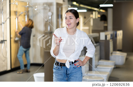 in plumbing department, woman thought about choosing suitable bathroom for new apartment in plumbing department, woman thought about choosing suitable bathroom for new apartment 120692636