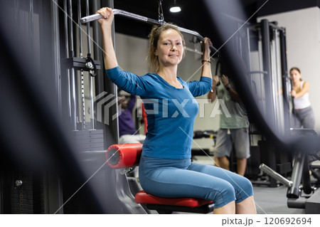 Athletic young woman works out on simulator 120692694