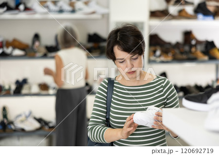 Woman takes samples from showcase and examines snickers Woman takes samples from showcase and examines snickers 120692719