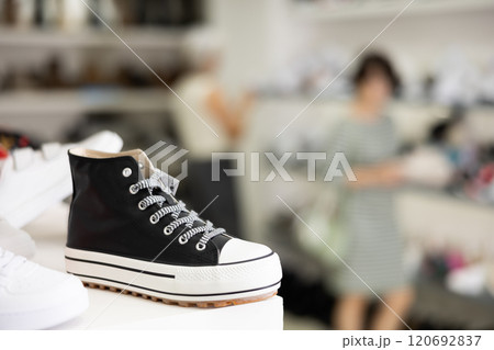 Sneakers displayed on shelf in shoe store Sneakers displayed on shelf in shoe store 120692837