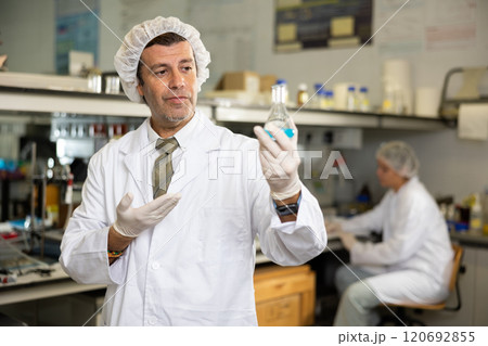 Portrait of an adult male using equipment to work in a laboratory 120692855