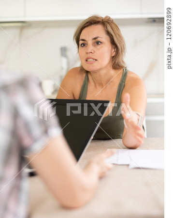 An insurance agent tells woman the terms of property and life insurance 120692899