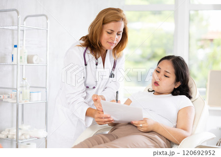 Middle-aged doctor consulting with documents Middle-aged doctor consulting with documents 120692952