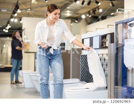 Woman choosing bathroom toilet bowl and utensils for his home Woman choosing bathroom toilet bowl and utensils for his home 120692965